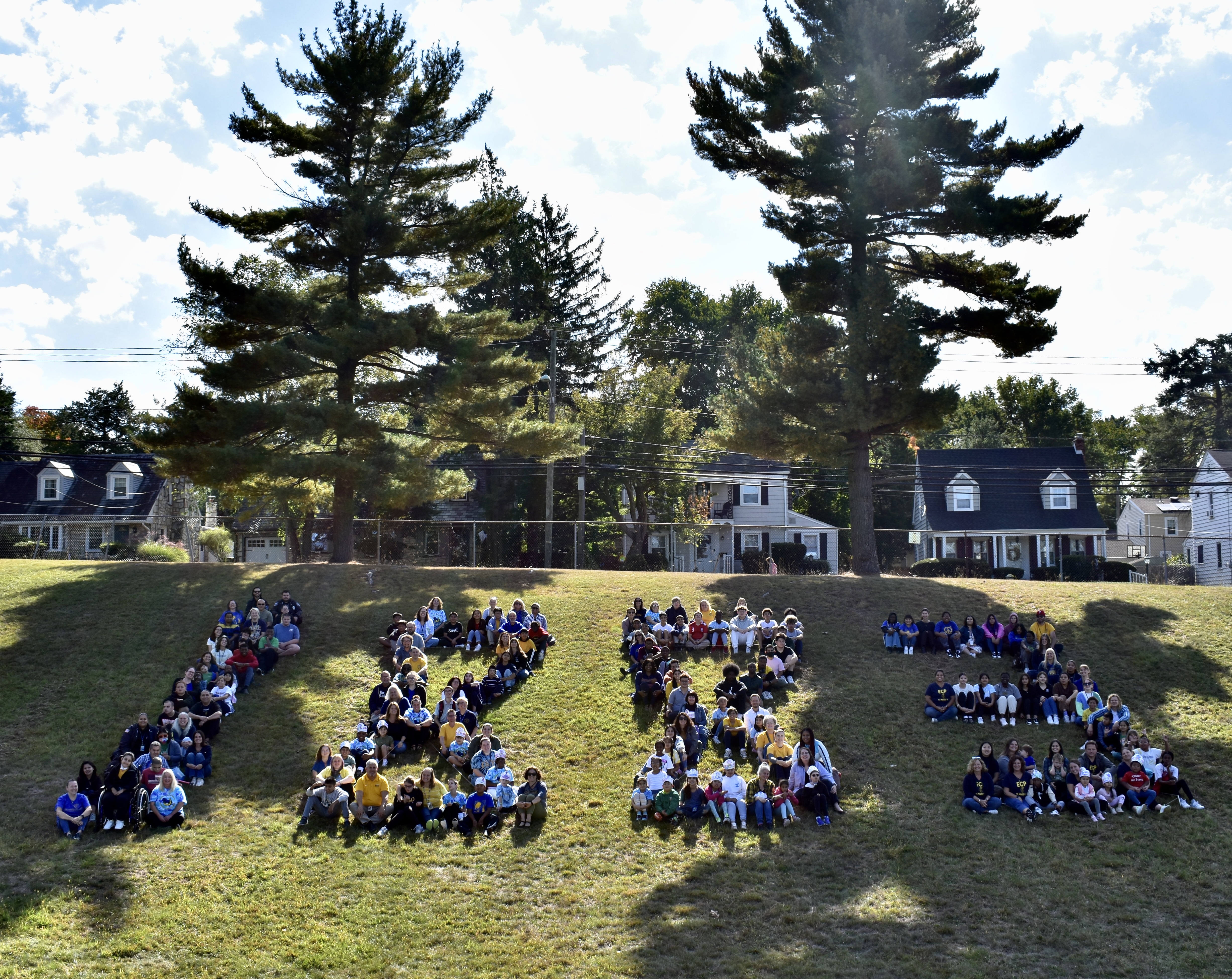 Students sitting on a hillside forming the number 1883